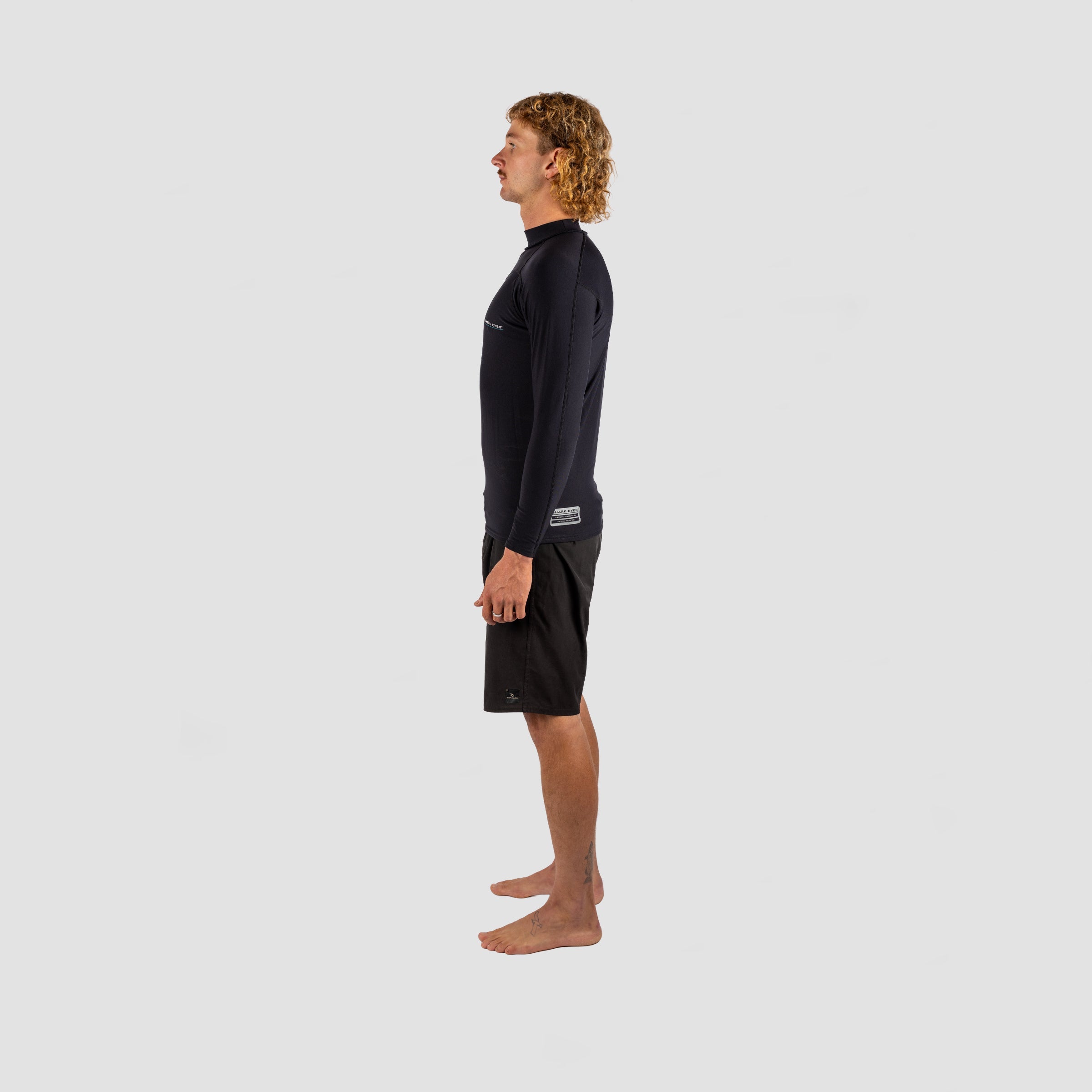 Shark Eyes thermal rash vest on mens in the ocean — cold water surf rashie