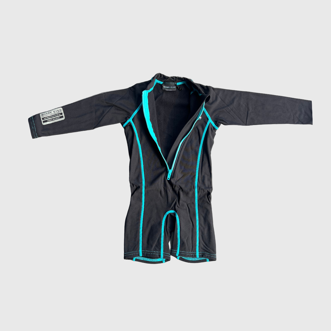 Black toddlers thermal wetsuit with teal trim on a gray surface